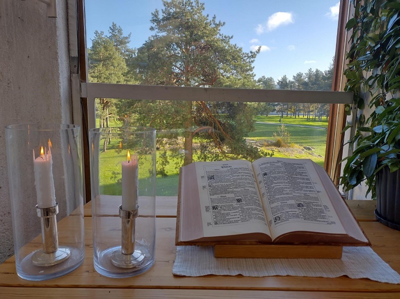 Raamattu pöydällä ikkunan edessä auki kohdasta psalmi 1.