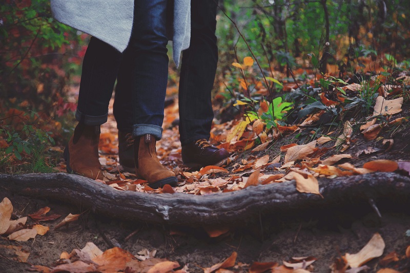 Kaksi kävelijää metsäpolulla, vain jalat näkyvät.